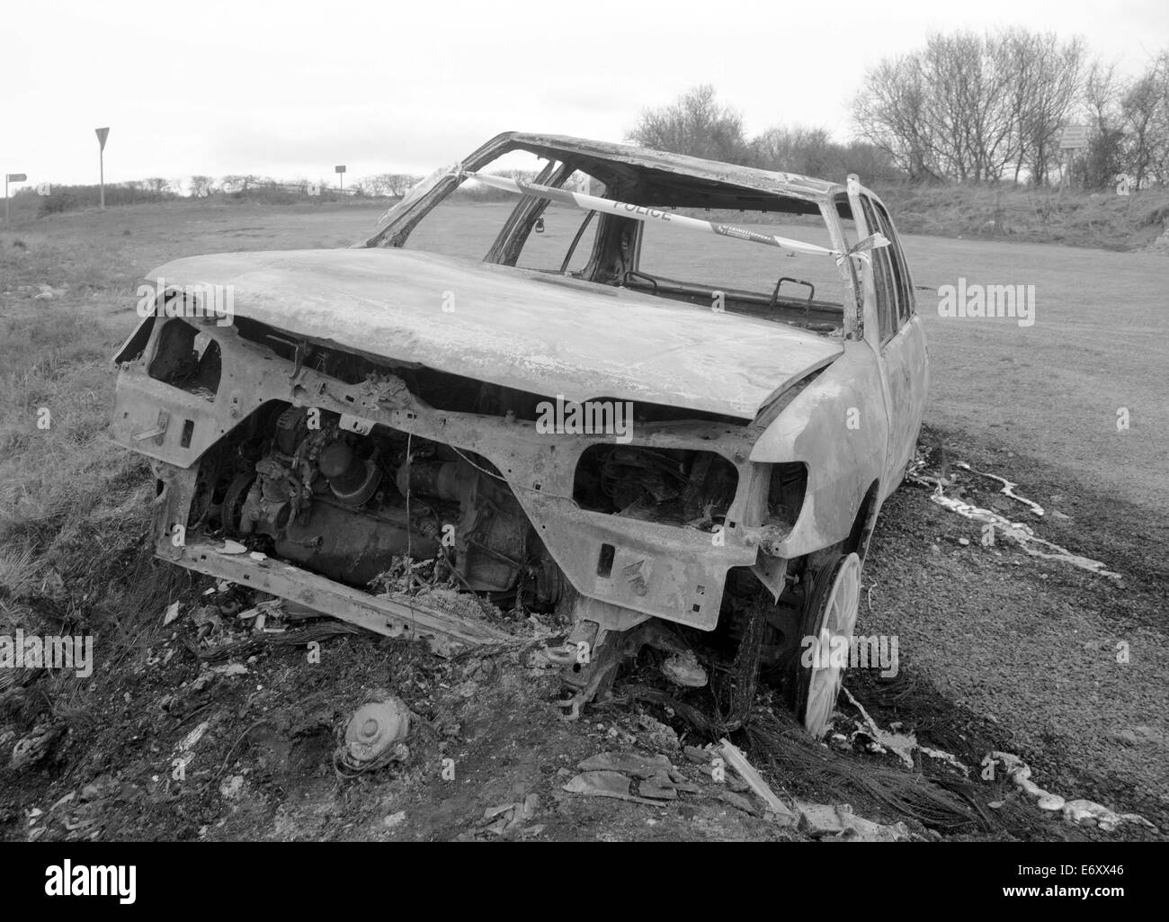 Bruciata abbandonata autovettura sul lato di una strada isolata. Foto Stock