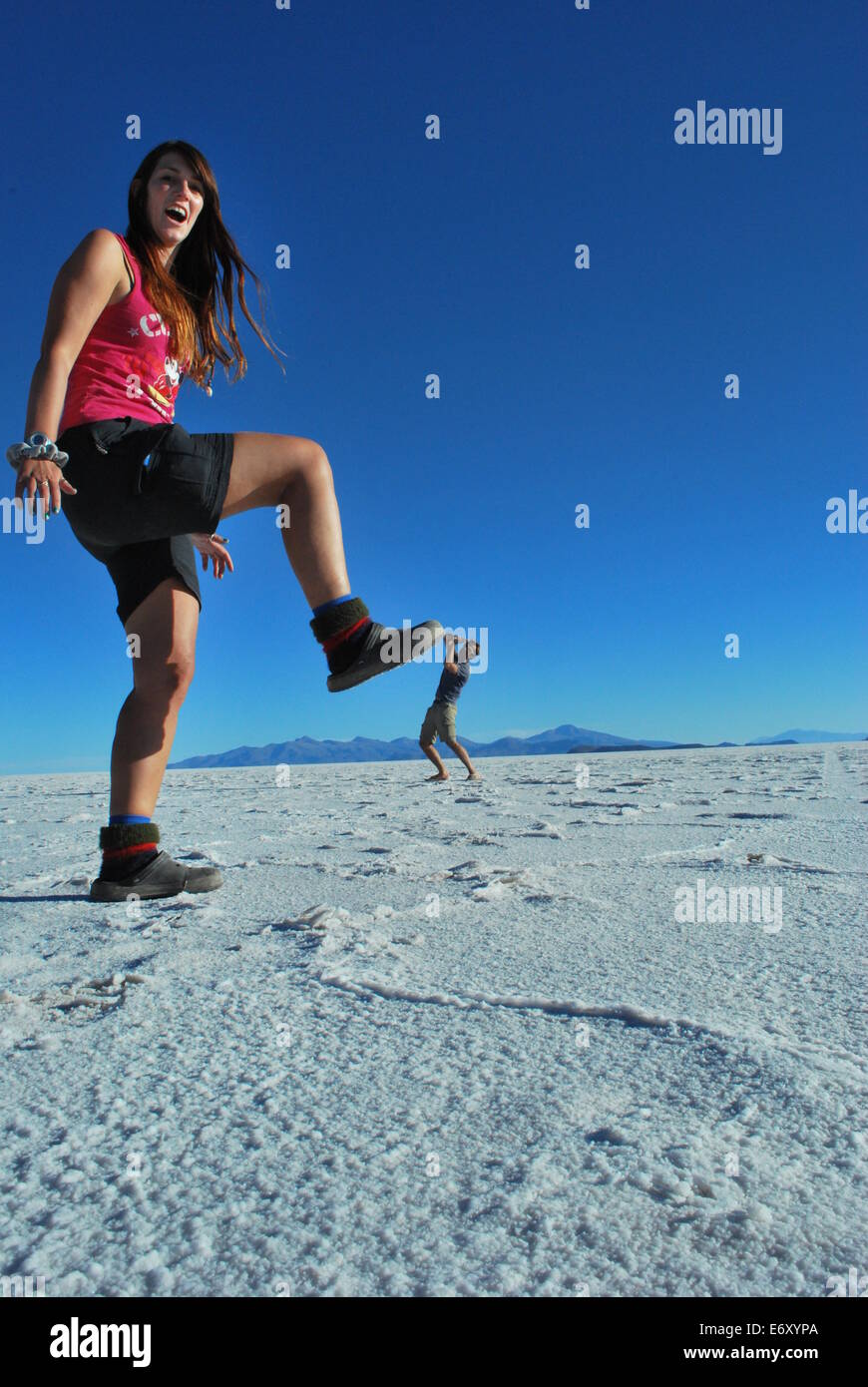 Colpo in prospettiva su una distesa di sale tour, Uyuni, Bolivia di una persona in frantumi da un gigantesco! Foto Stock