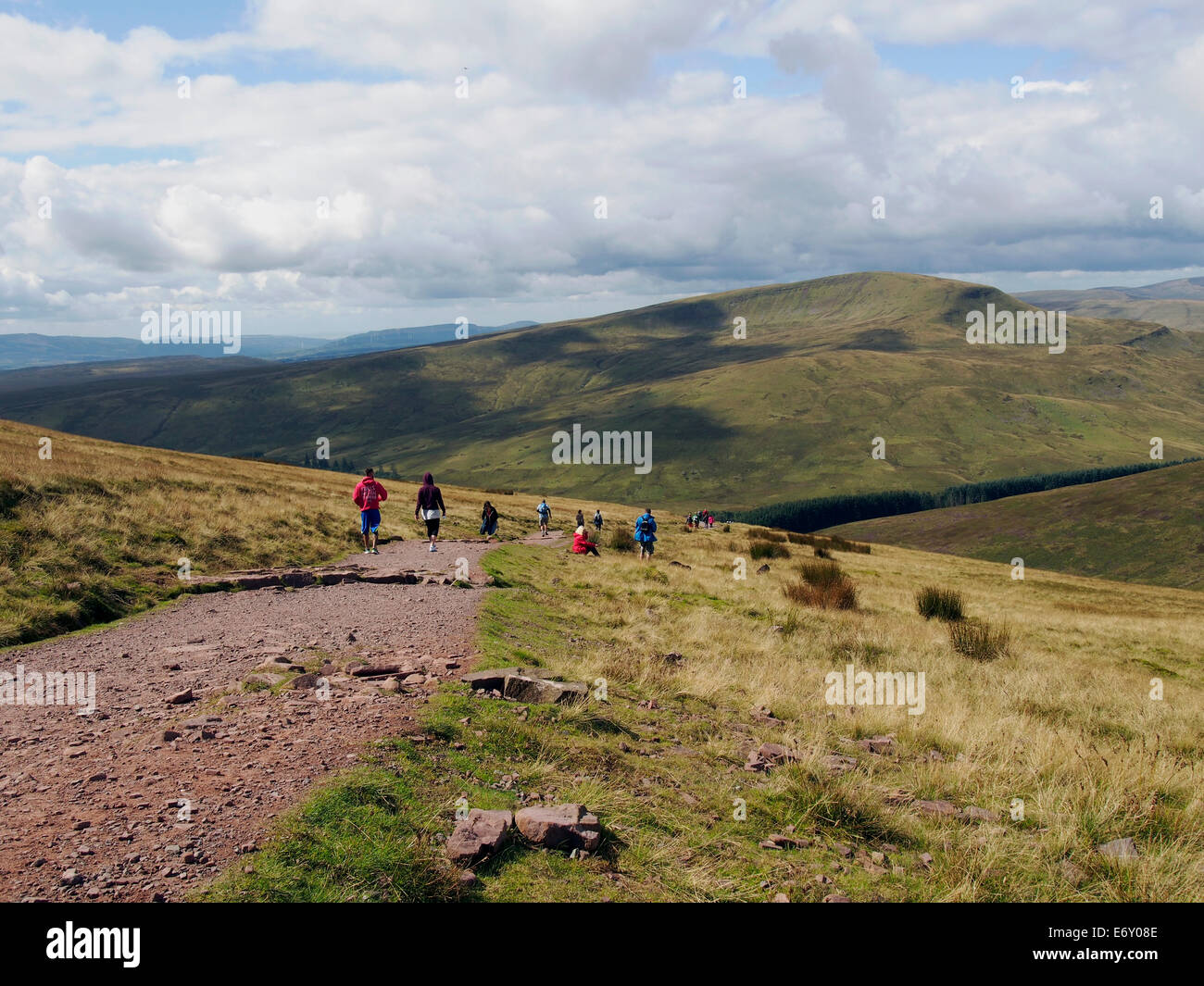 Passeggiate in collina in Brecon Beacons. Walkers scendendo verso piani di bracci sul sentiero principale con Fforest Fawr al di là. Foto Stock