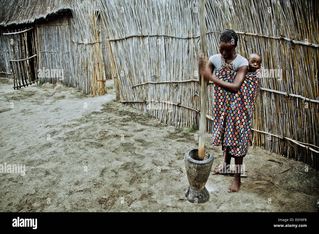 Giovane madre della tribù Lozi con baby pounding grano in un grande mortaio di legno, Caprivi regione, Namibia, Africa Foto Stock Giovane madre della tribù Lozi con baby pounding grano in un grande mortaio di legno, Caprivi regione, Namibia, Africa Foto Stock