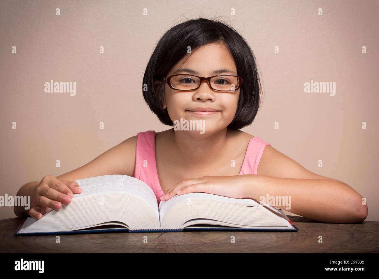 Ragazza con gli occhiali lettura a casa Foto Stock