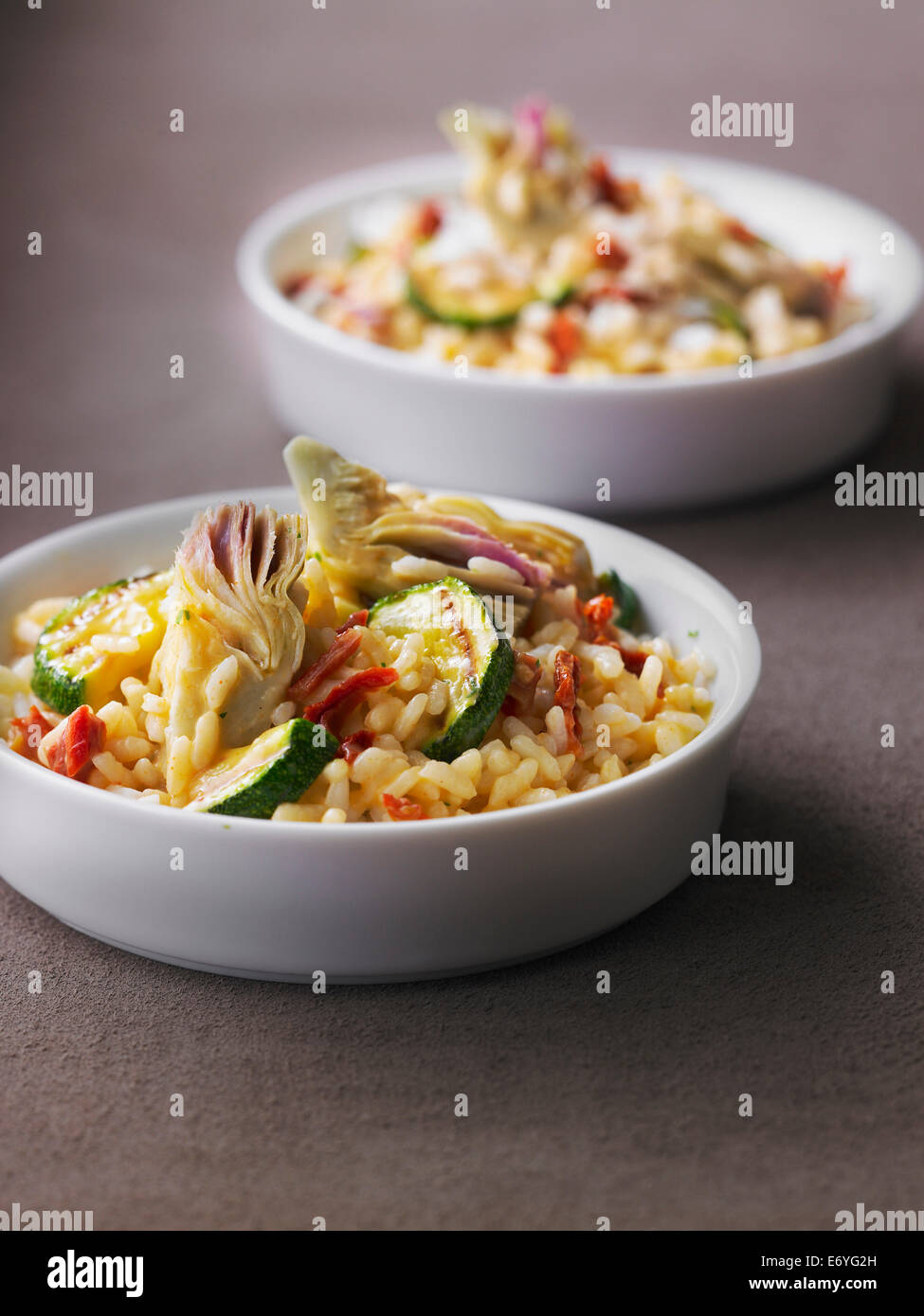 Risotto con carciofi, zucchine e pomodori secchi Foto Stock