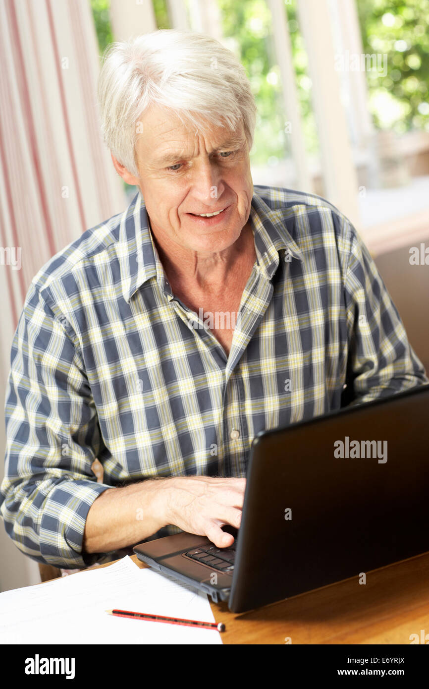 Età metà uomo che lavora in ufficio a casa Foto Stock