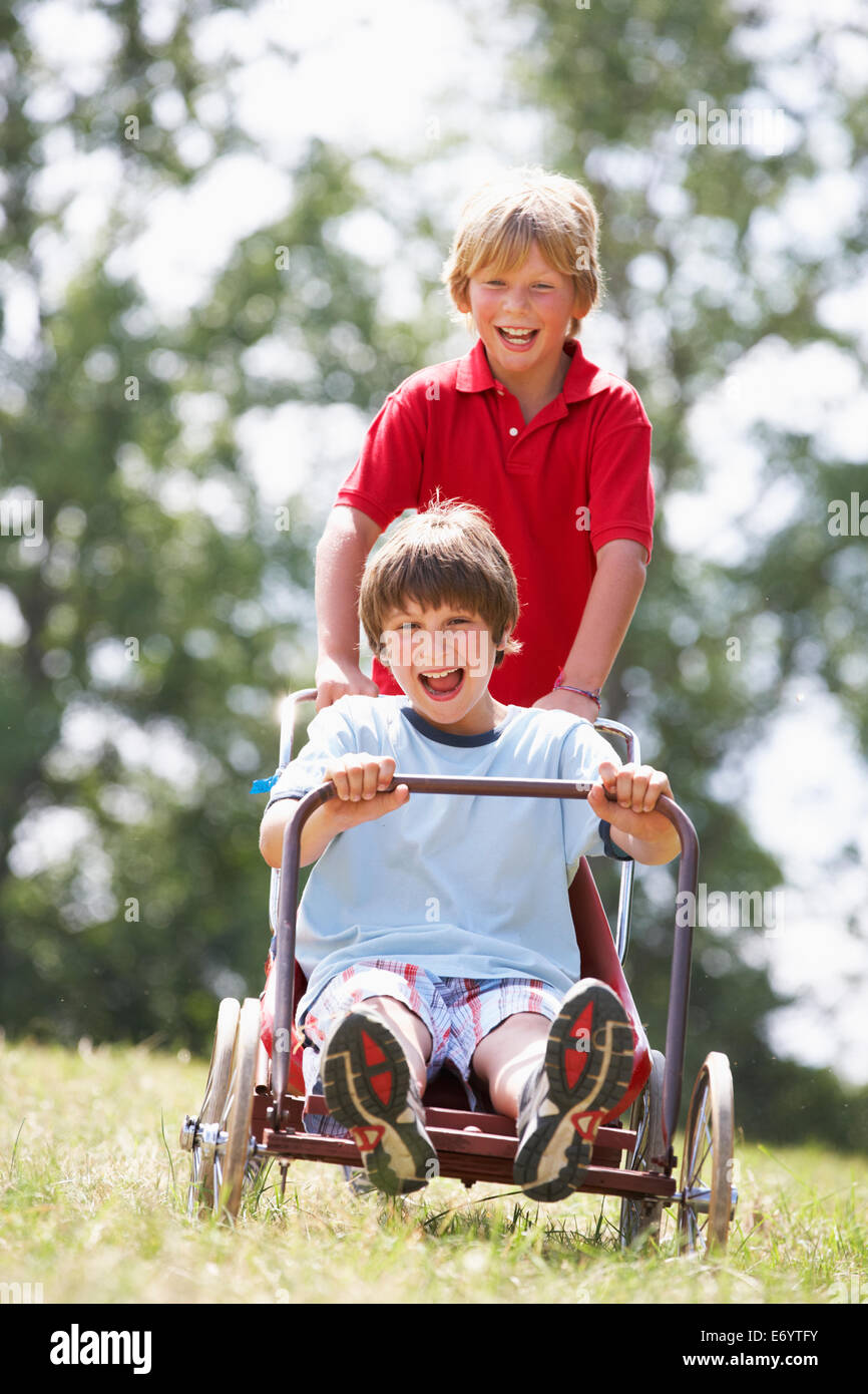 I ragazzi giocare con go-kart Foto Stock