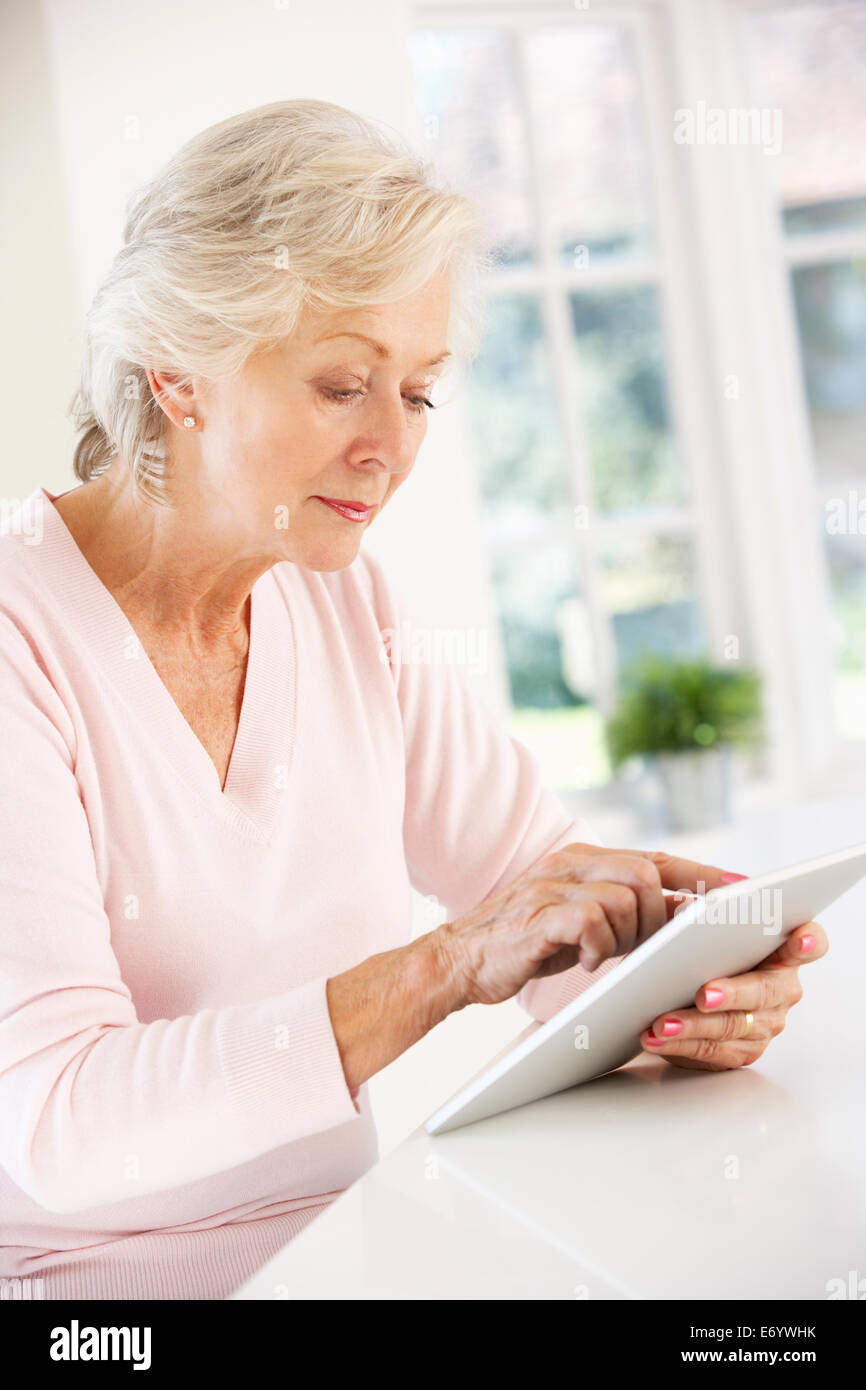 Senior donna utilizzando tablet a casa Foto Stock
