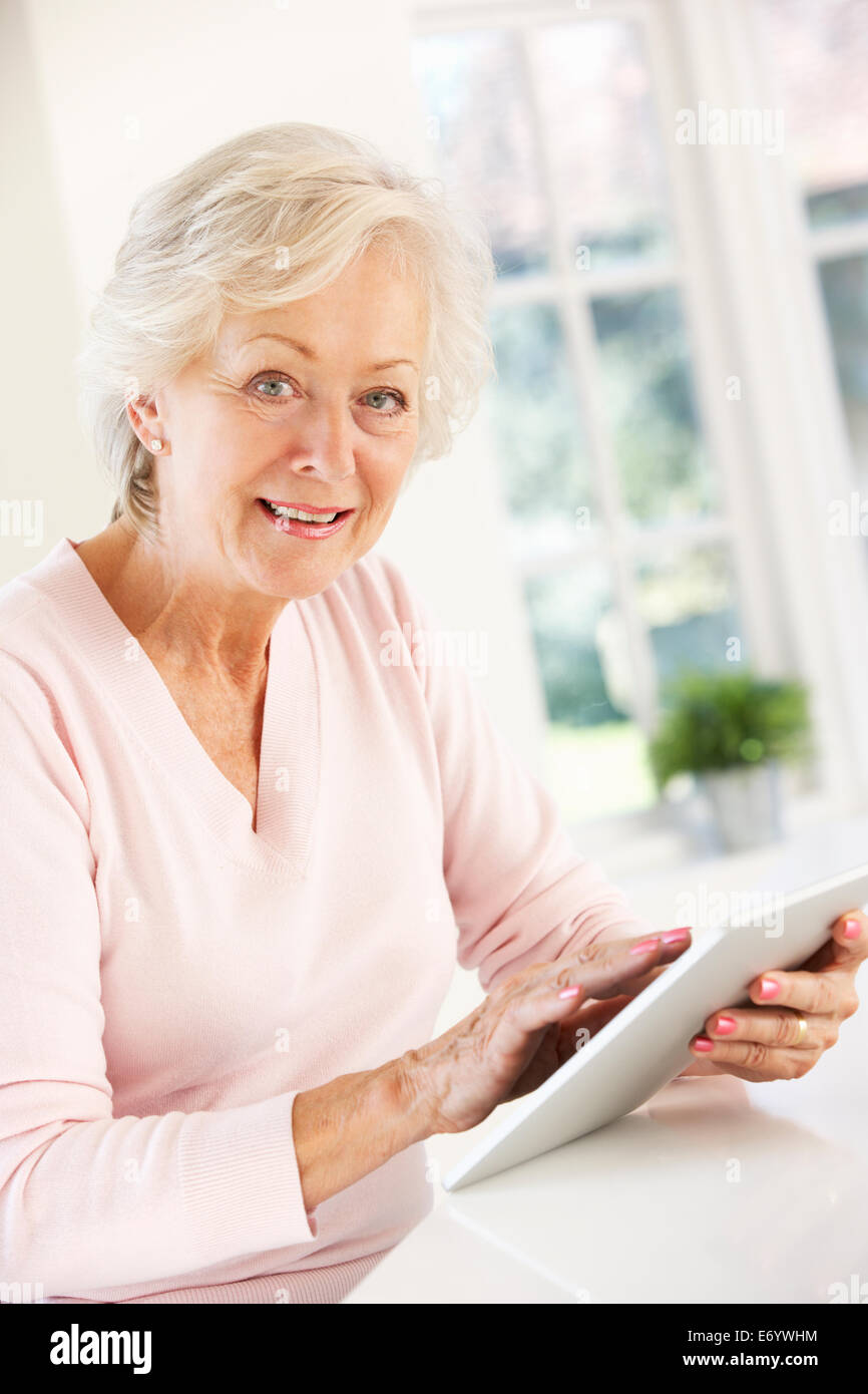 Senior donna utilizzando tablet a casa Foto Stock