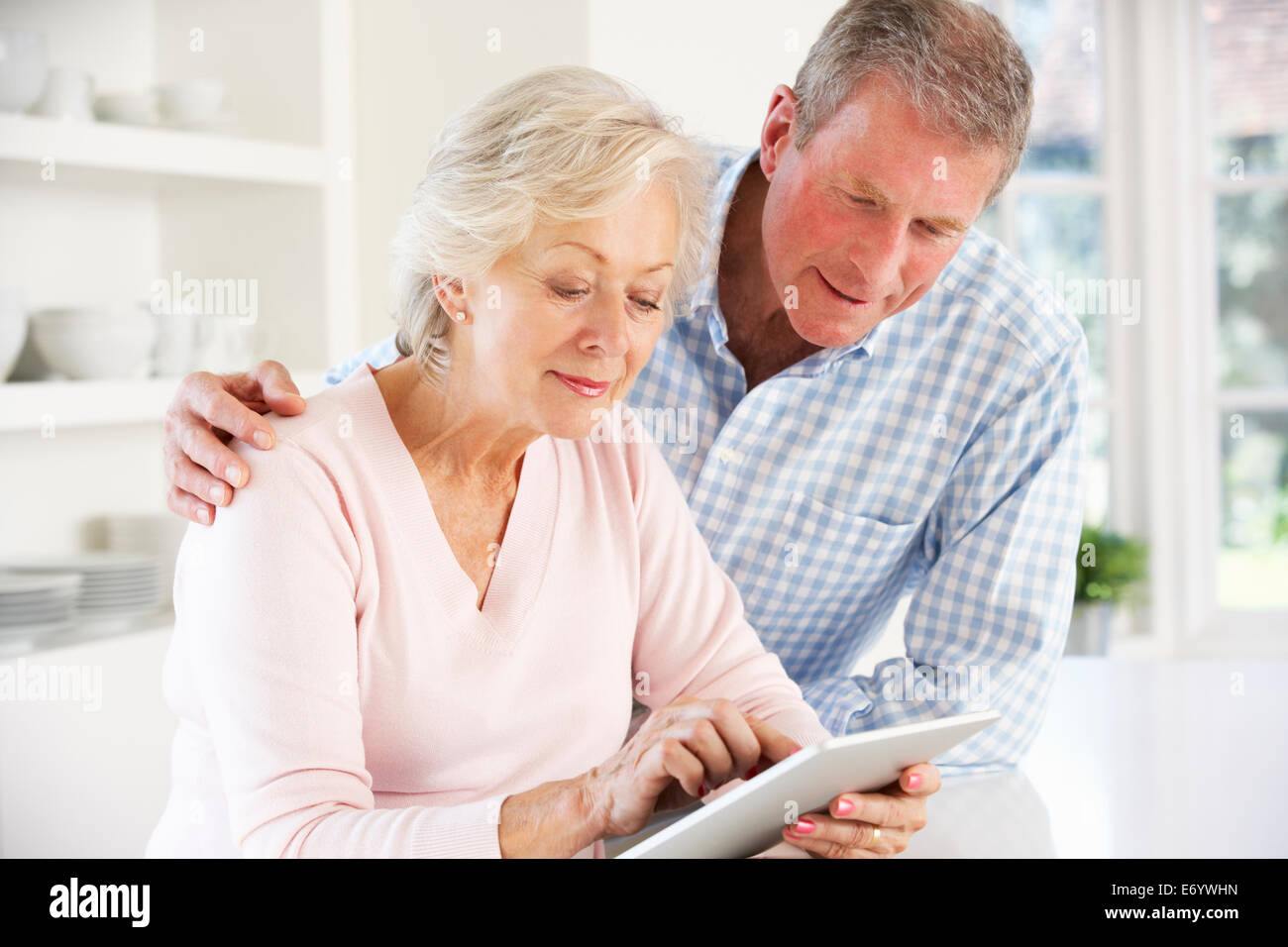Coppia senior utilizzando tablet a casa Foto Stock