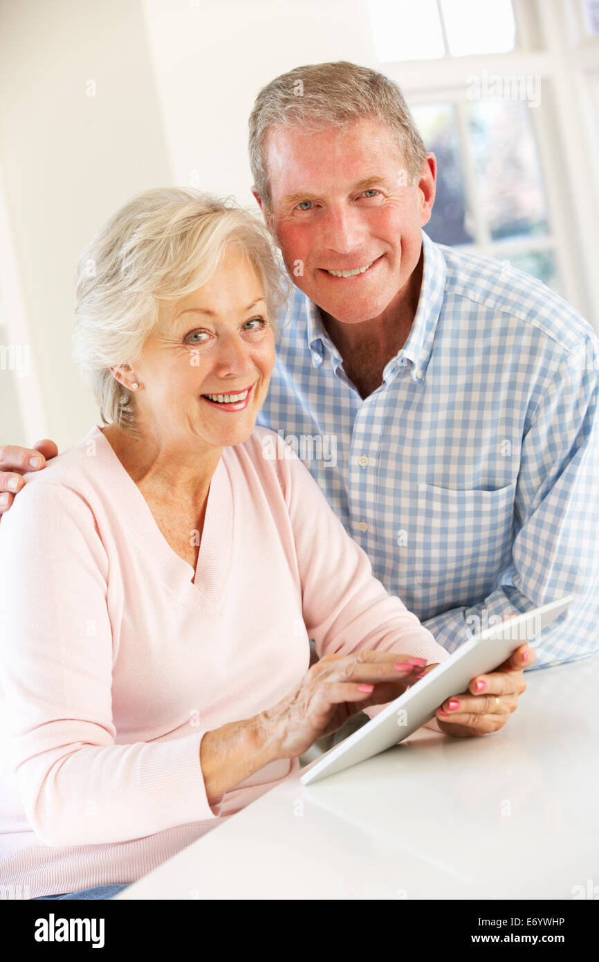 Coppia senior utilizzando tablet a casa Foto Stock