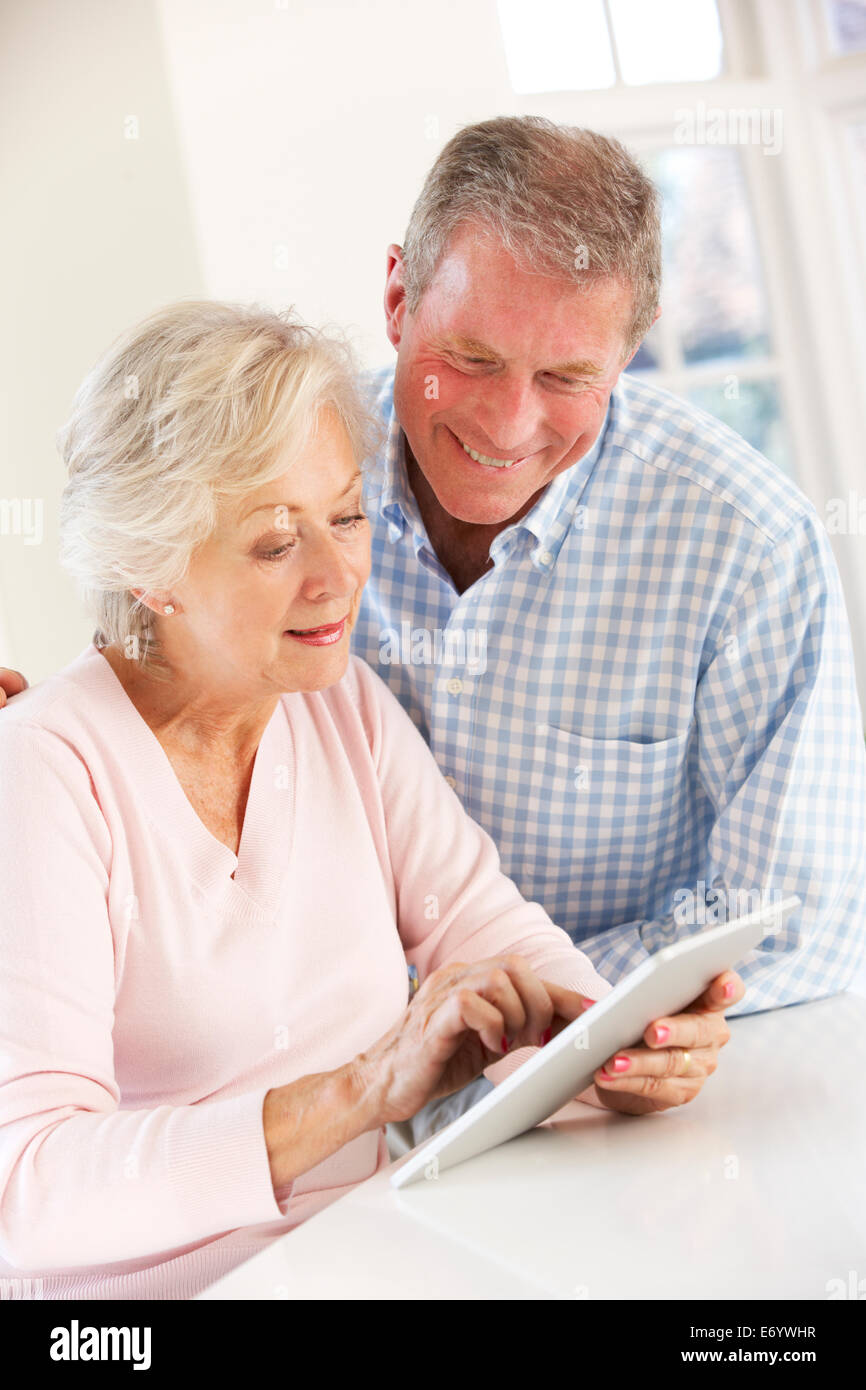 Coppia senior utilizzando tablet a casa Foto Stock