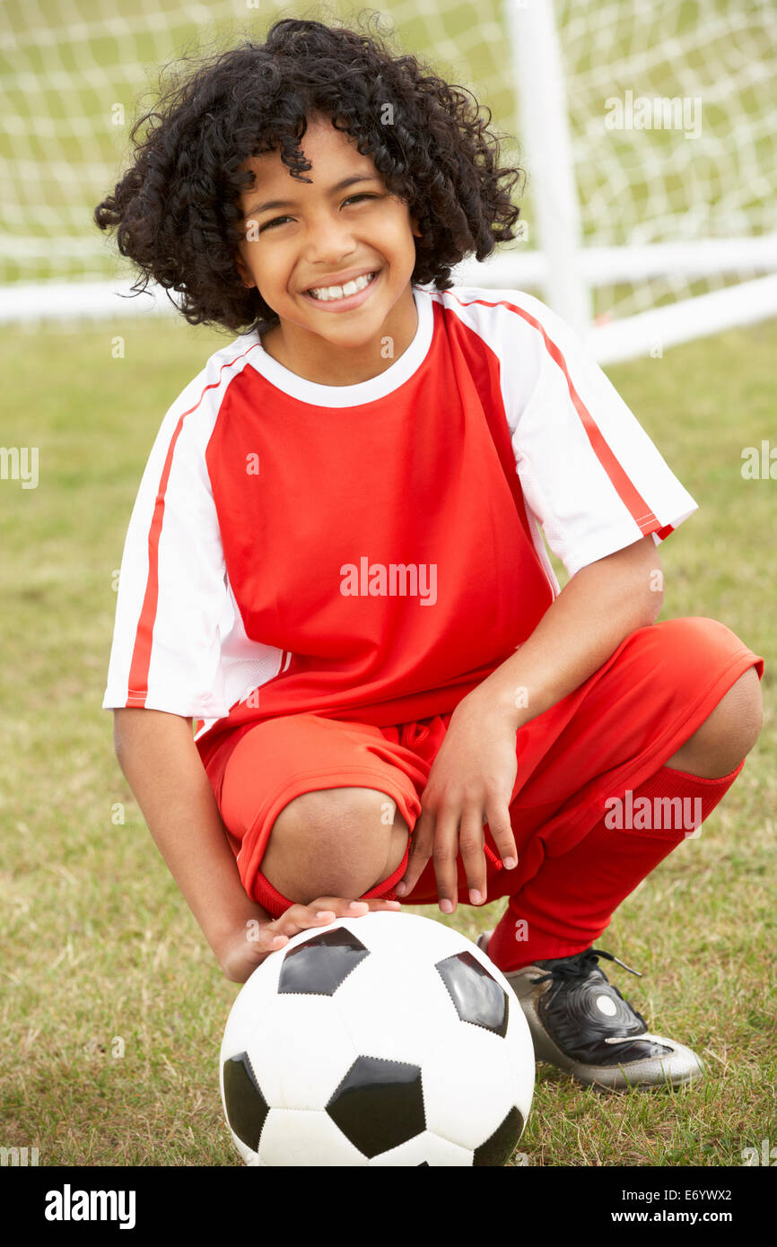 Ritratto ragazzo in kit di calcio con sfera Foto Stock