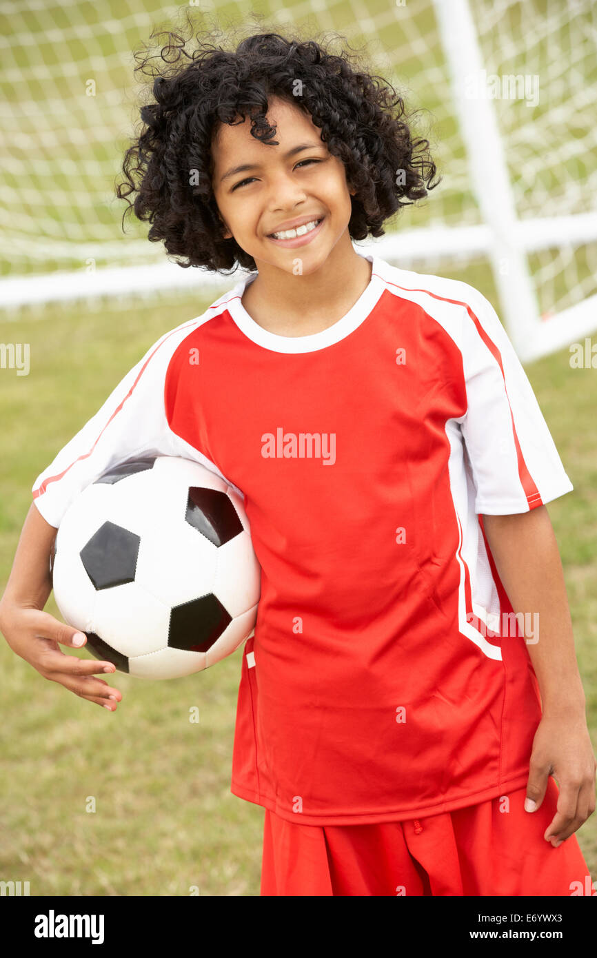 Ritratto ragazzo in kit calcio con sfera Foto Stock