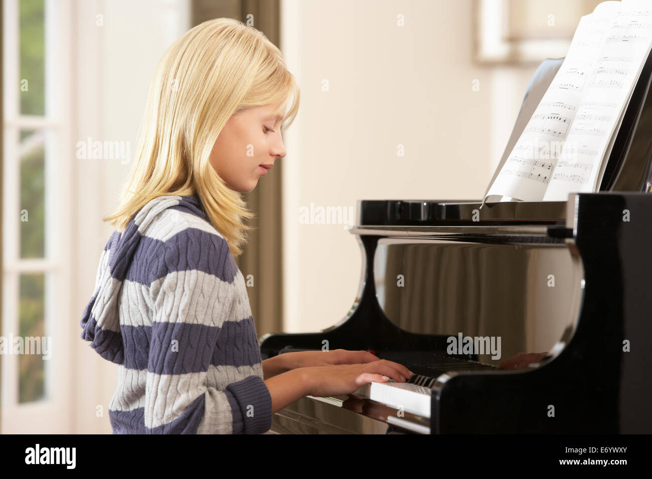 Ragazza che gioca un pianoforte a casa Foto Stock
