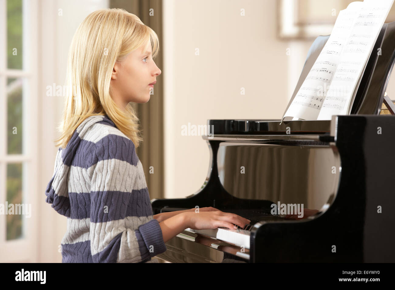 Ragazza che gioca un pianoforte a casa Foto Stock