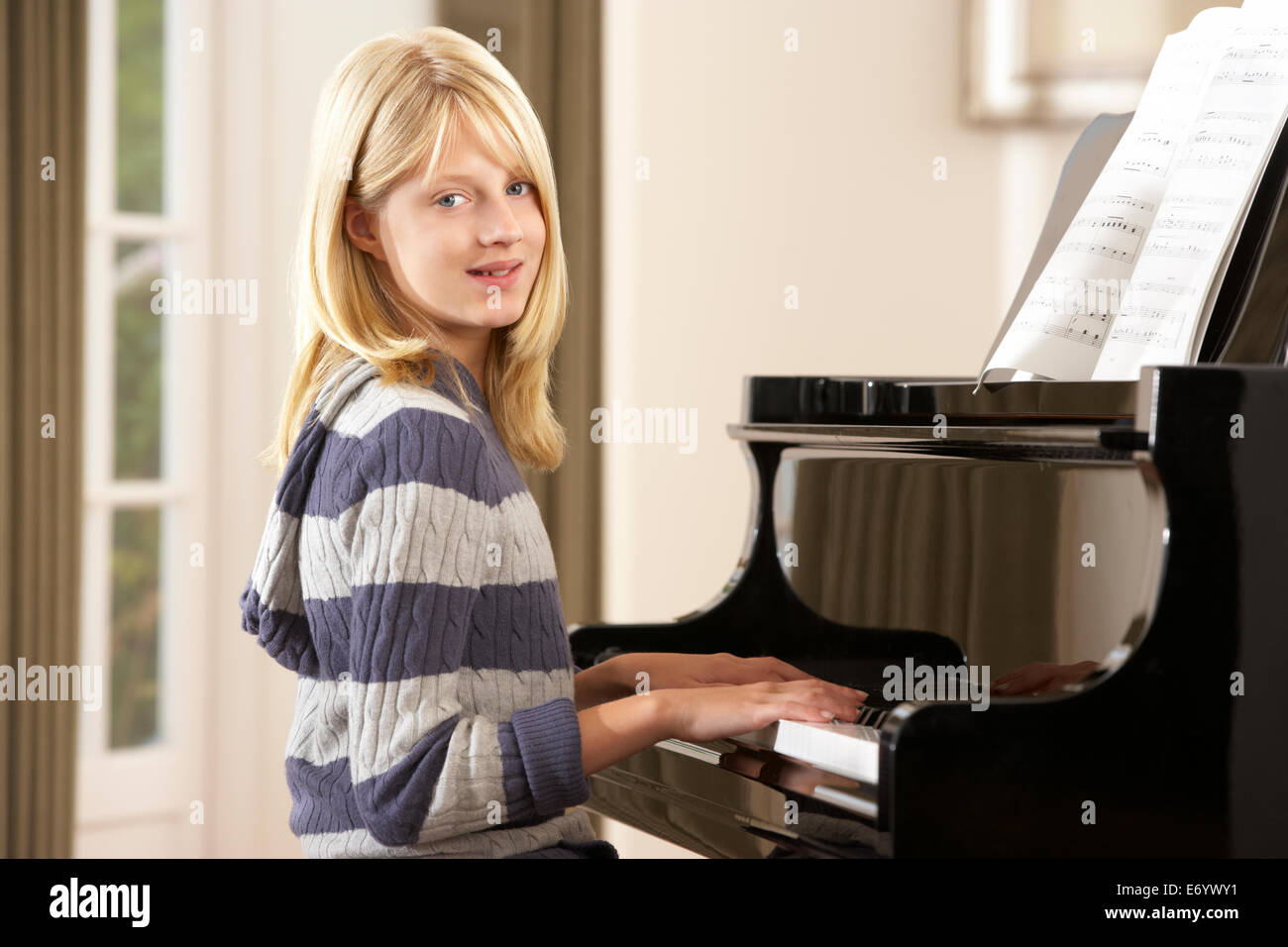 Ragazza che gioca un pianoforte a casa Foto Stock