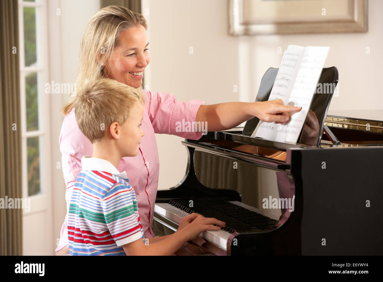 Ragazzo giovane nella lezione con insegnante di pianoforte Foto Stock