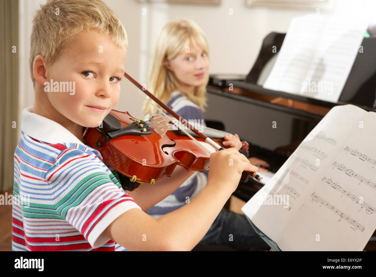 Un ragazzo e una ragazza suona il violino e pianoforte a casa Foto Stock