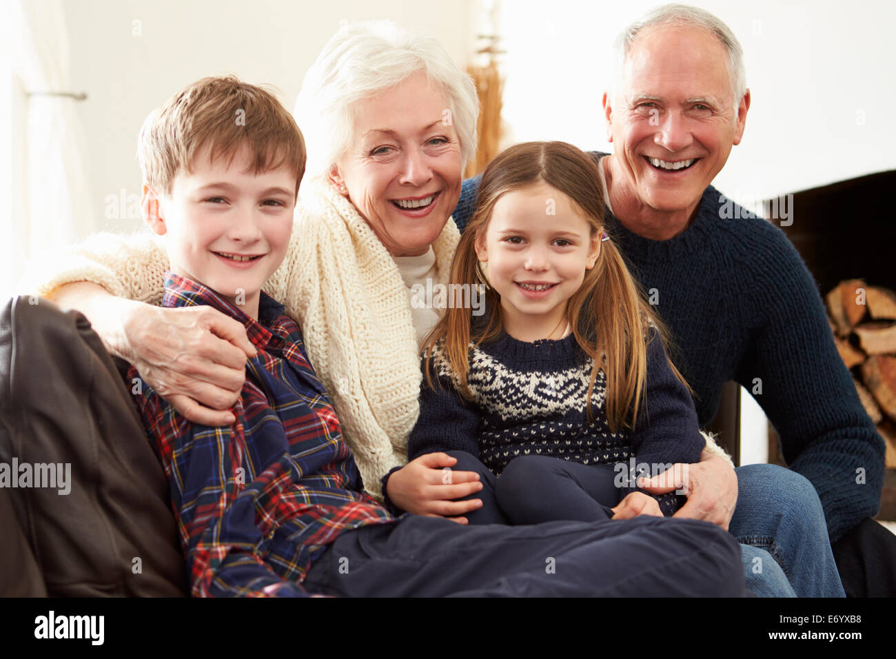 Ritratto di nonni seduti sul divano con i nipoti Foto Stock
