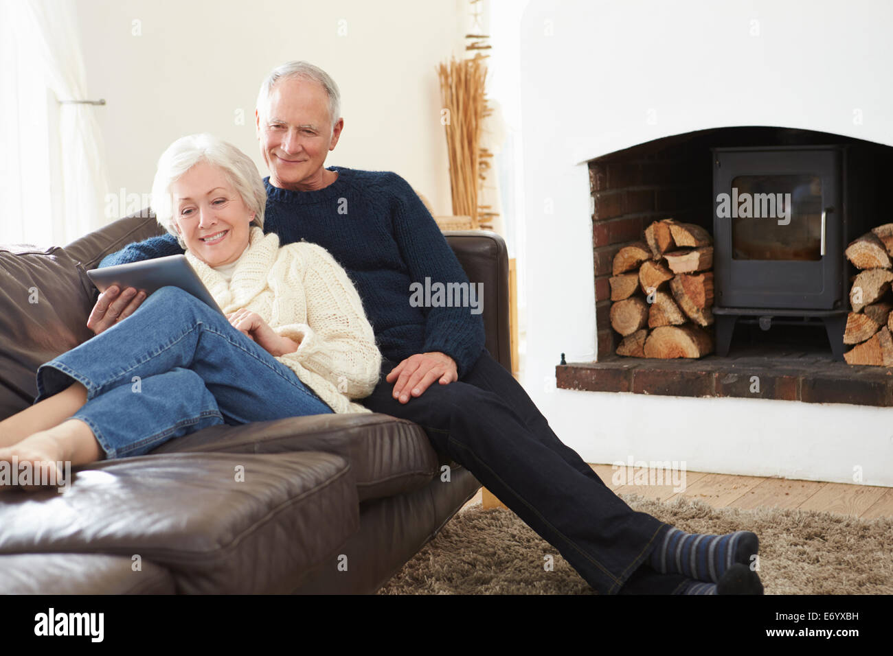 Coppia senior con tavoletta digitale sul divano Foto Stock