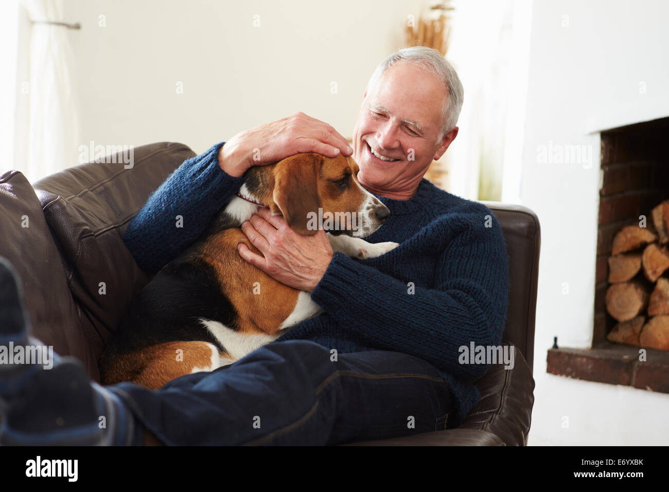 Uomo Senior in un momento di relax a casa con il cane Foto Stock