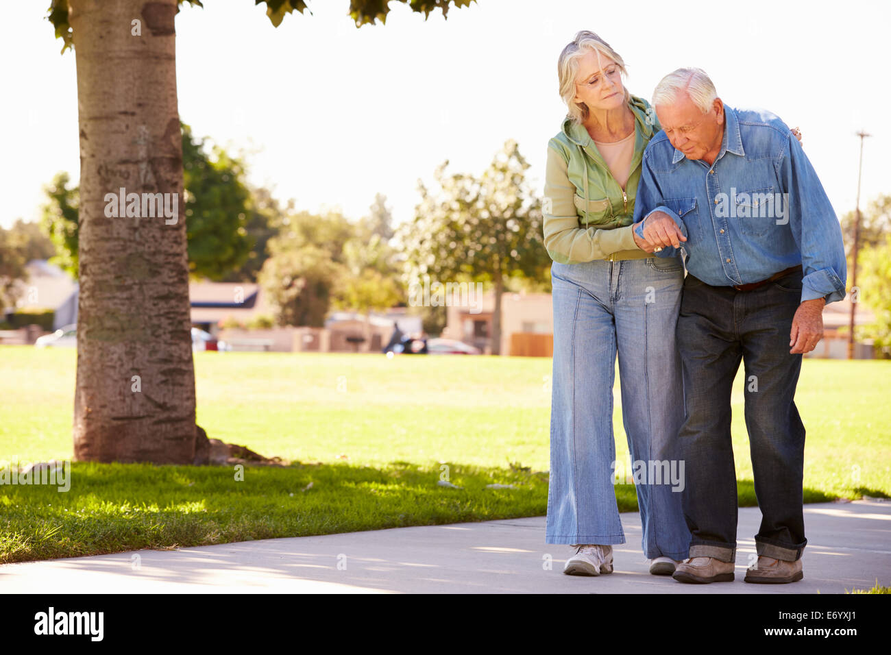 Senior donna aiutando il marito in quanto a Piedi nel Parco insieme Foto Stock