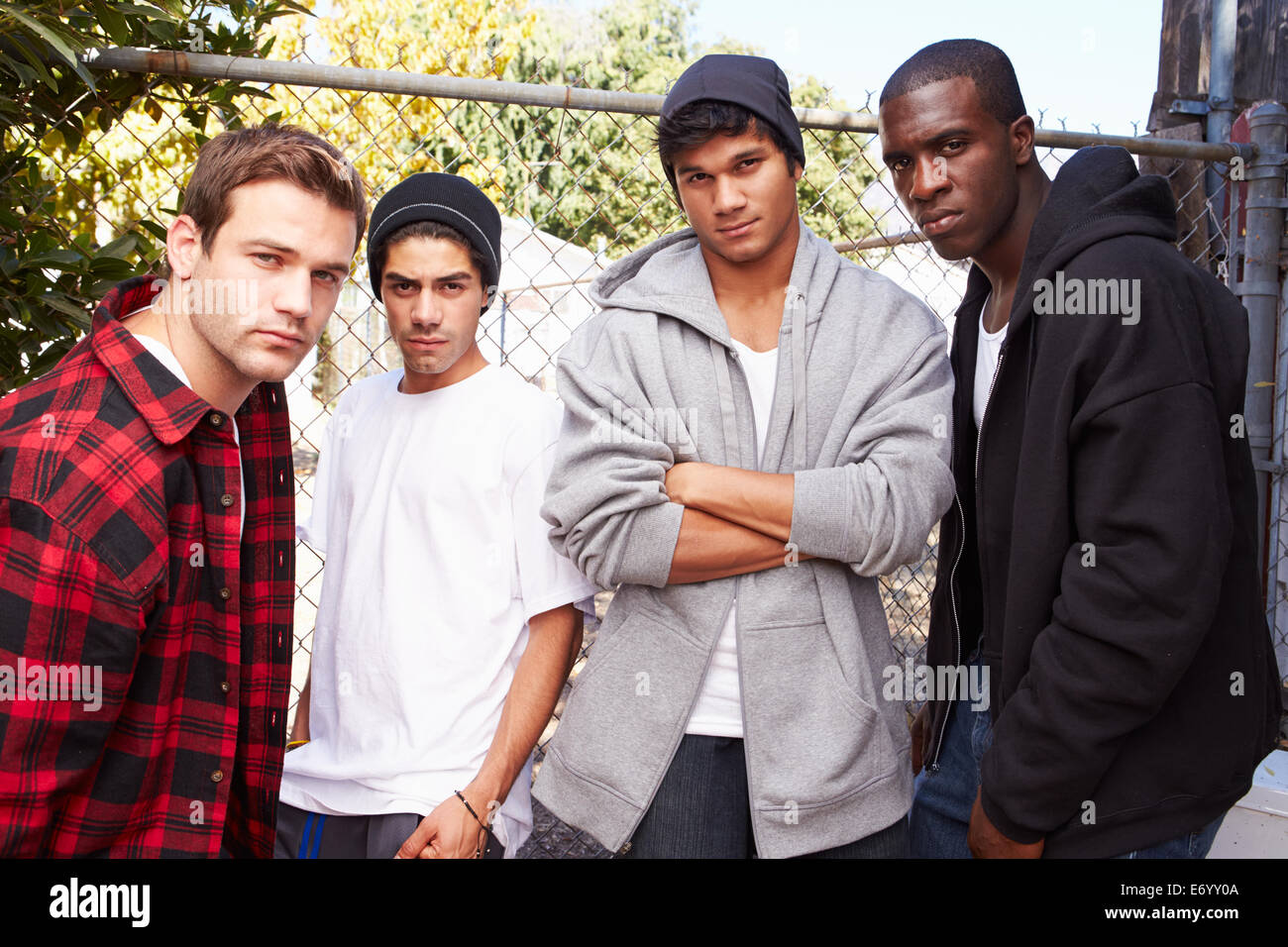 Un gruppo di giovani uomini in assetto urbano in piedi da recinzione Foto Stock