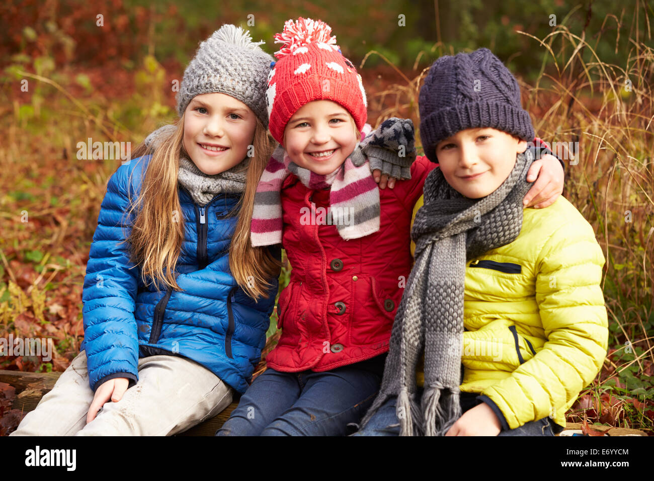 Tre bambini su a piedi attraverso il bosco invernale Foto Stock