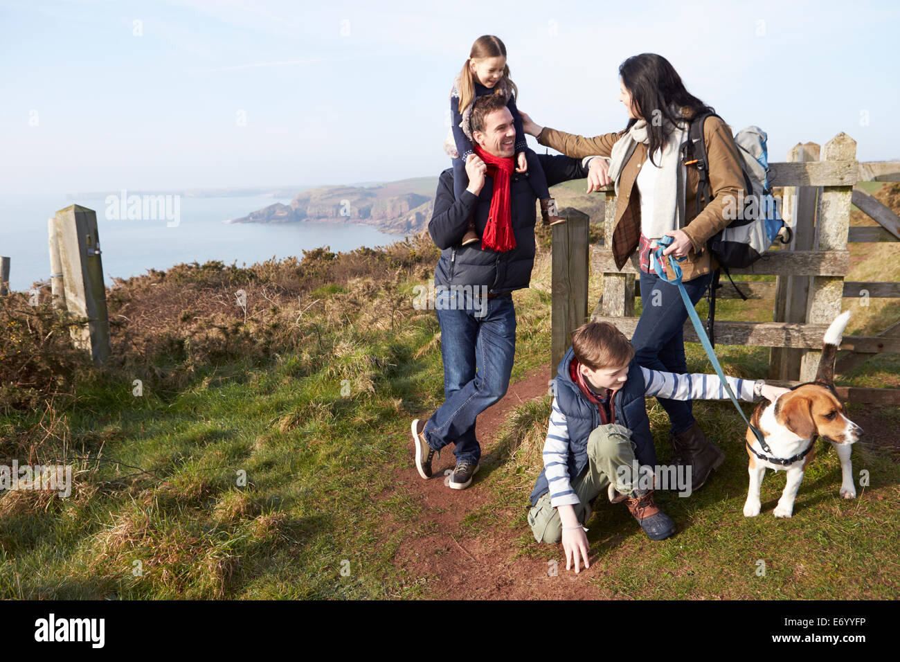 Famiglia con il cane a camminare lungo il sentiero costiero Foto Stock