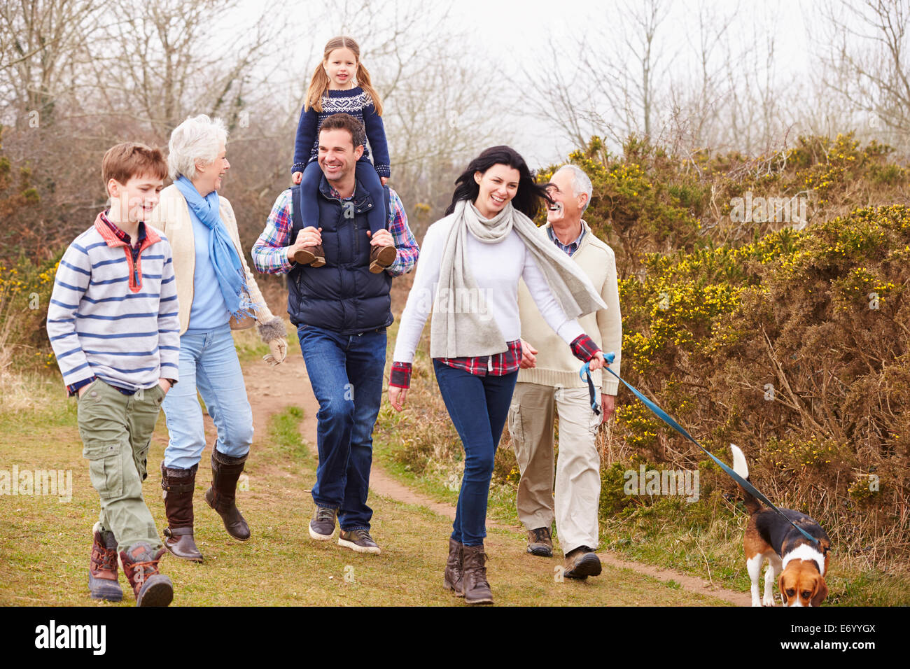 Multi generazione Famiglia con cane sulla campagna a piedi Foto Stock