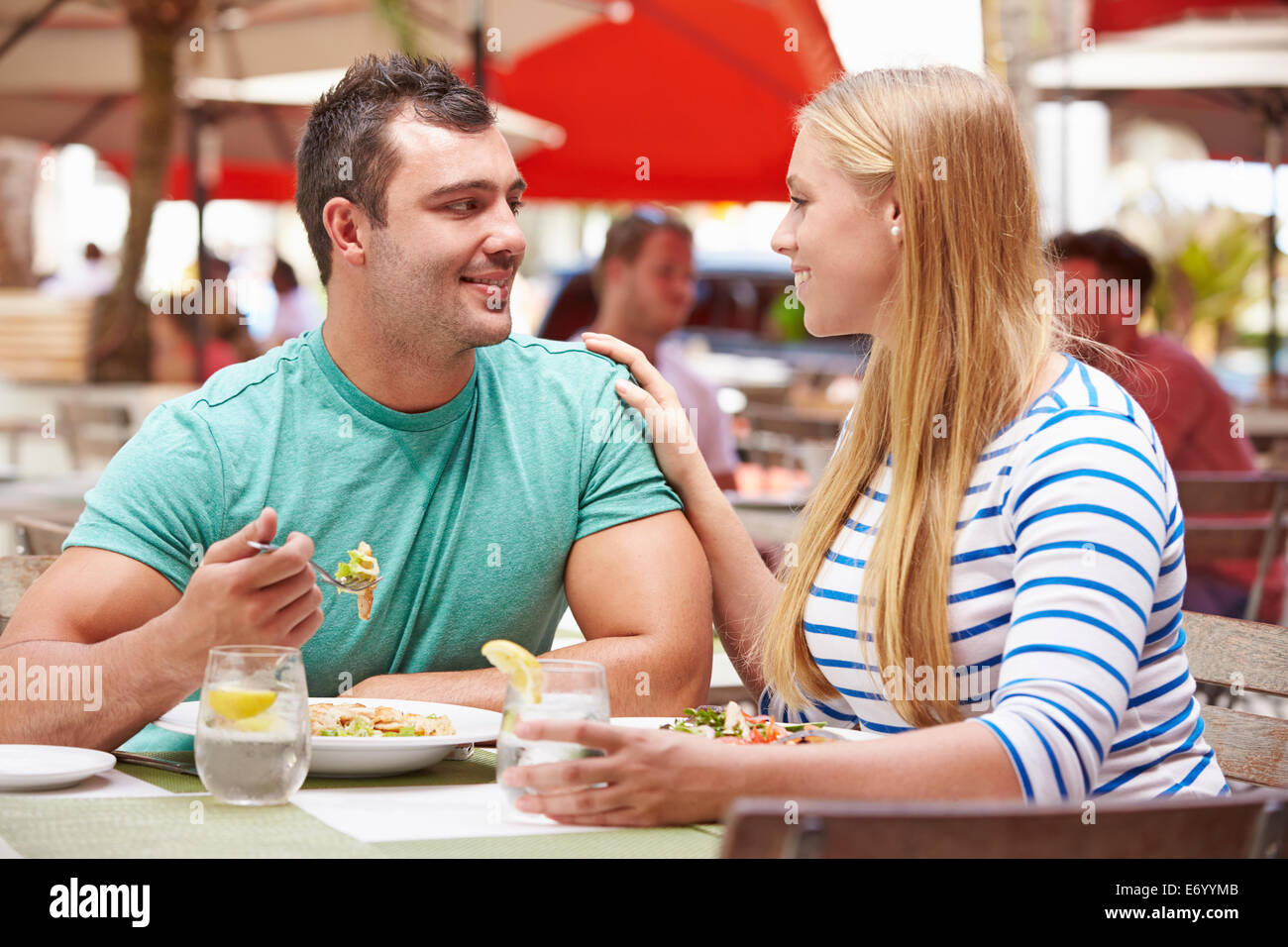 Giovane godendo il pranzo in un ristorante esterno Foto Stock