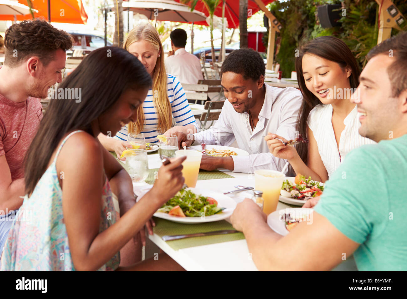 Gruppo di amici gustando un pranzo in un ristorante esterno Foto Stock