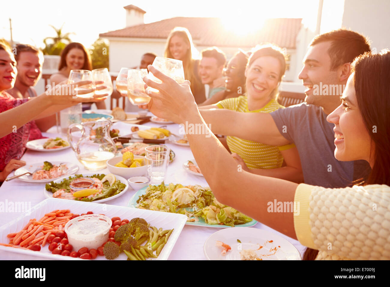 Un gruppo di giovani godendo Outdoor pasto estivo Foto Stock