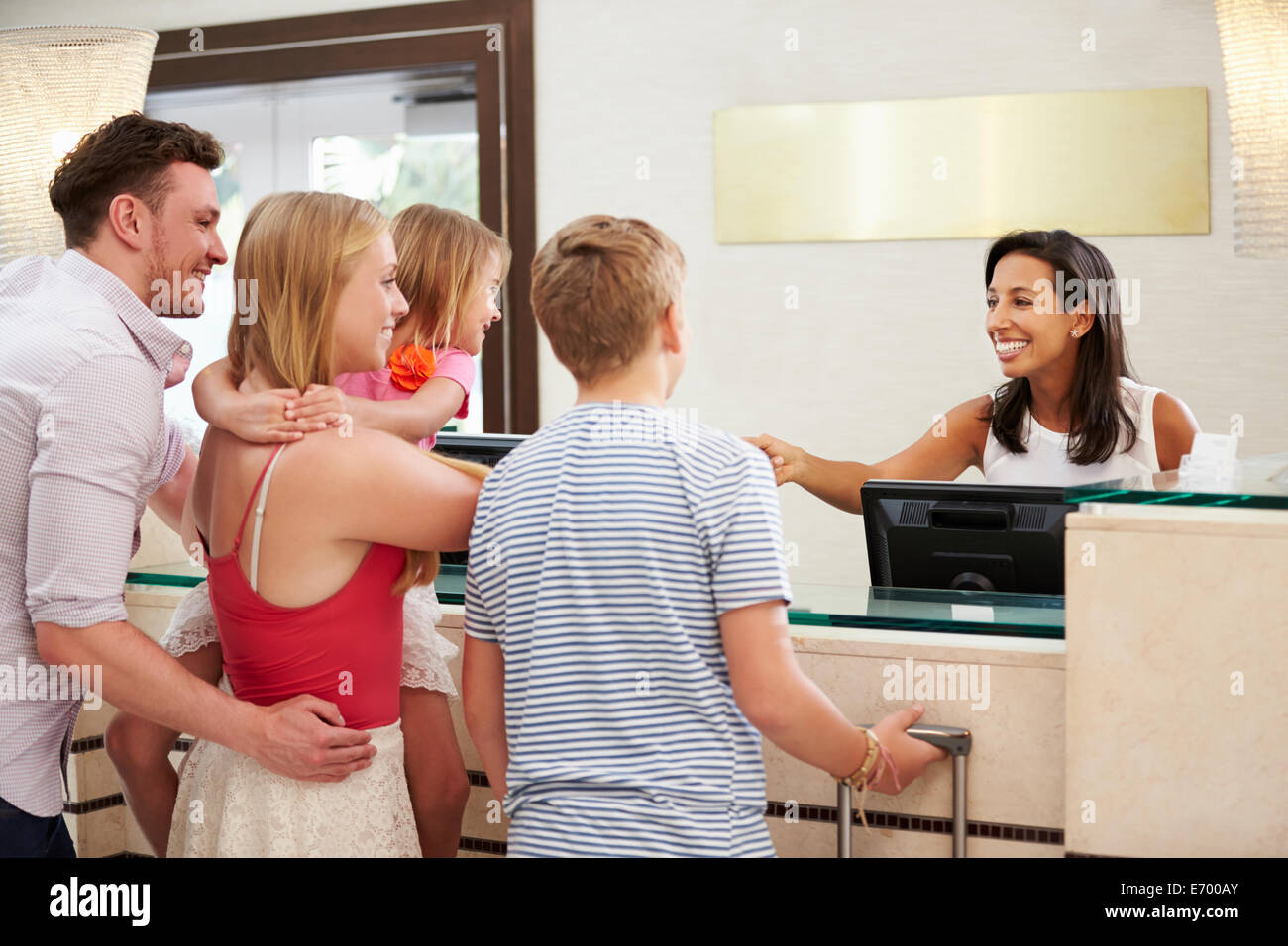 Famiglia il check in presso la reception dell'Hotel Foto Stock