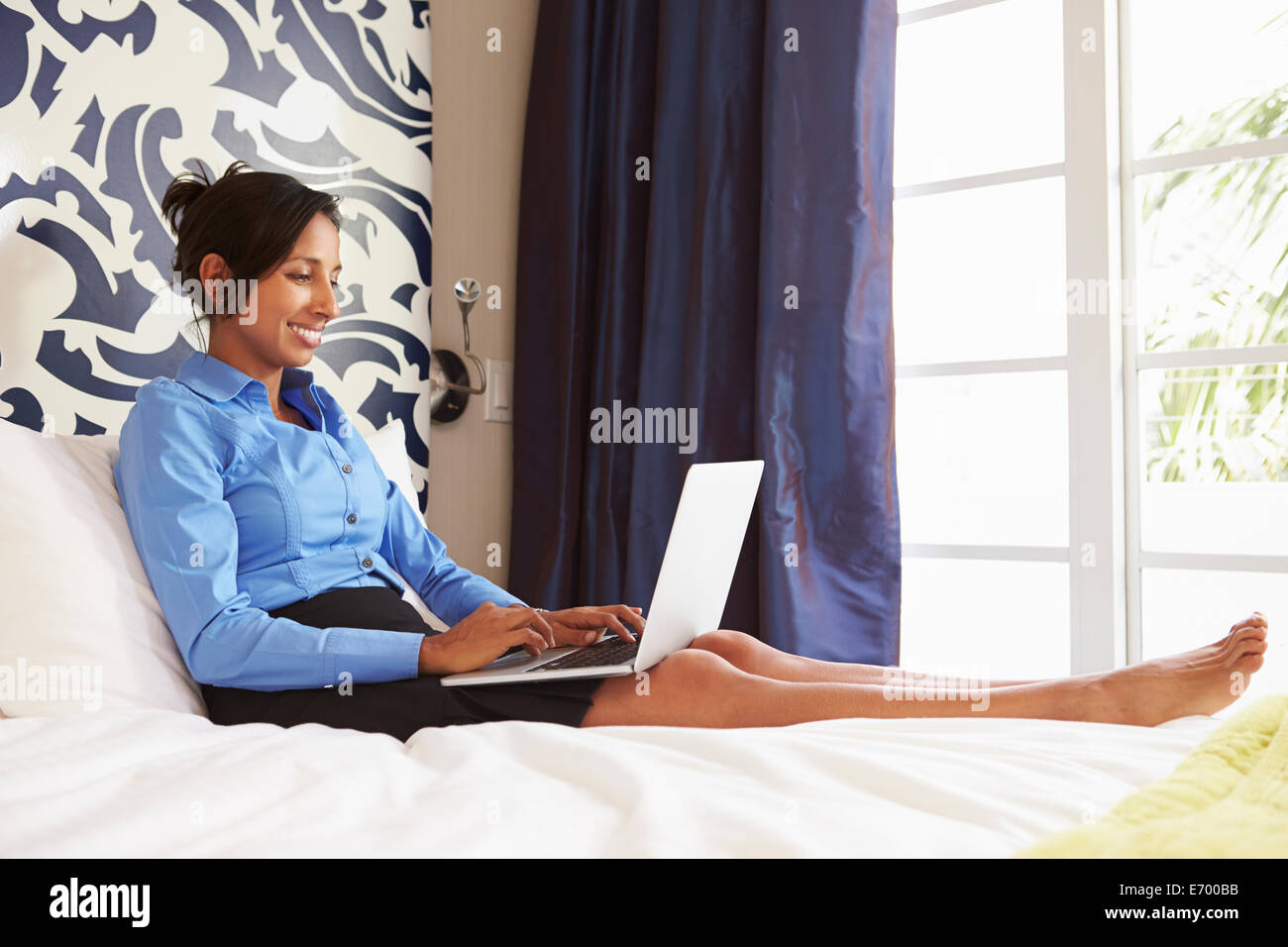 Imprenditrice lavorando sul computer portatile in camera di albergo Foto Stock