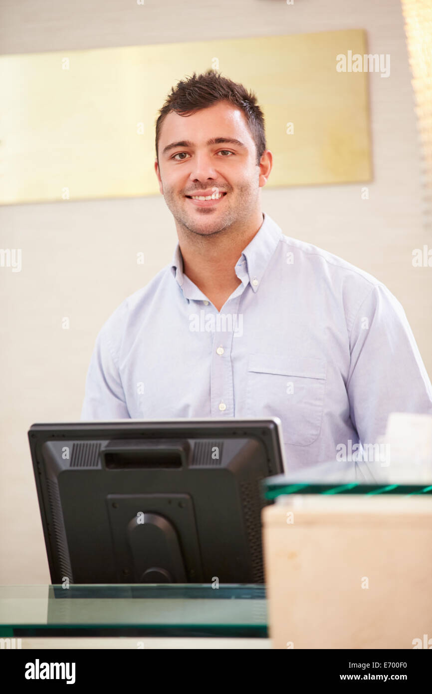 Ritratto maschile di receptionist presso Hotel Front Desk Foto Stock