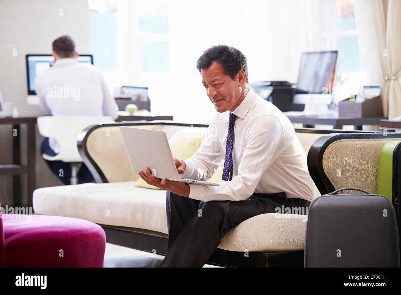 Imprenditore lavora su computer portatile nella Hall Hotel Foto Stock