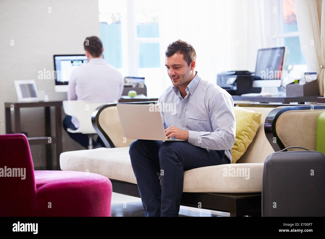 Imprenditore lavora su computer portatile nella Hall Hotel Foto Stock