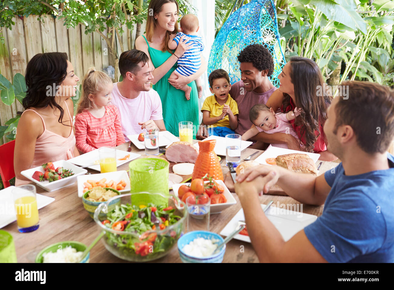 Gruppo di famiglie godendo Outdoor pasto a casa Foto Stock