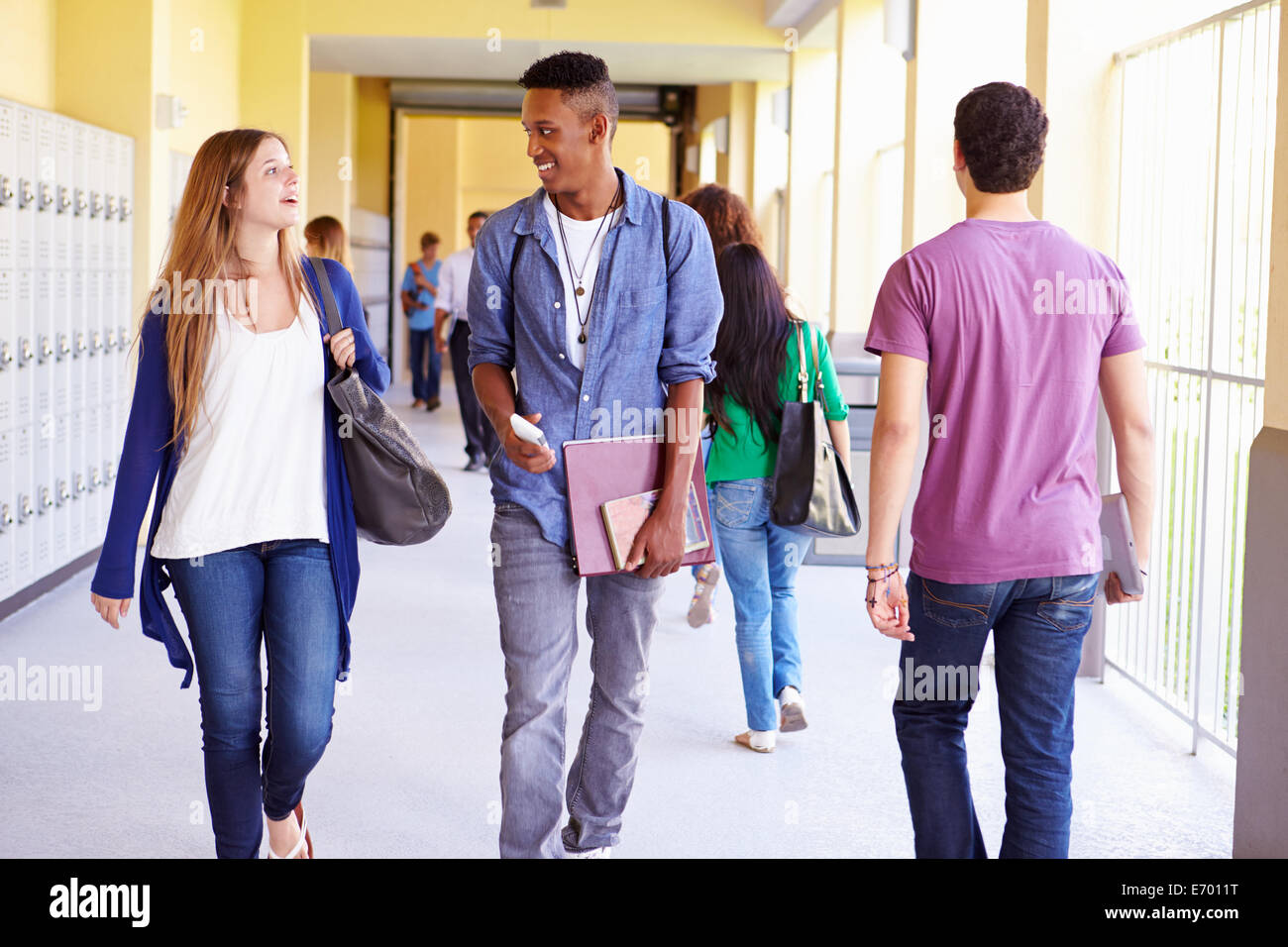 Un gruppo di studenti di scuola superiore a camminare lungo il corridoio Foto Stock