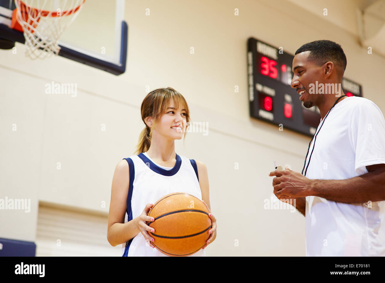 Femmina di alta scuola giocatore di basket a parlare con pullman Foto Stock