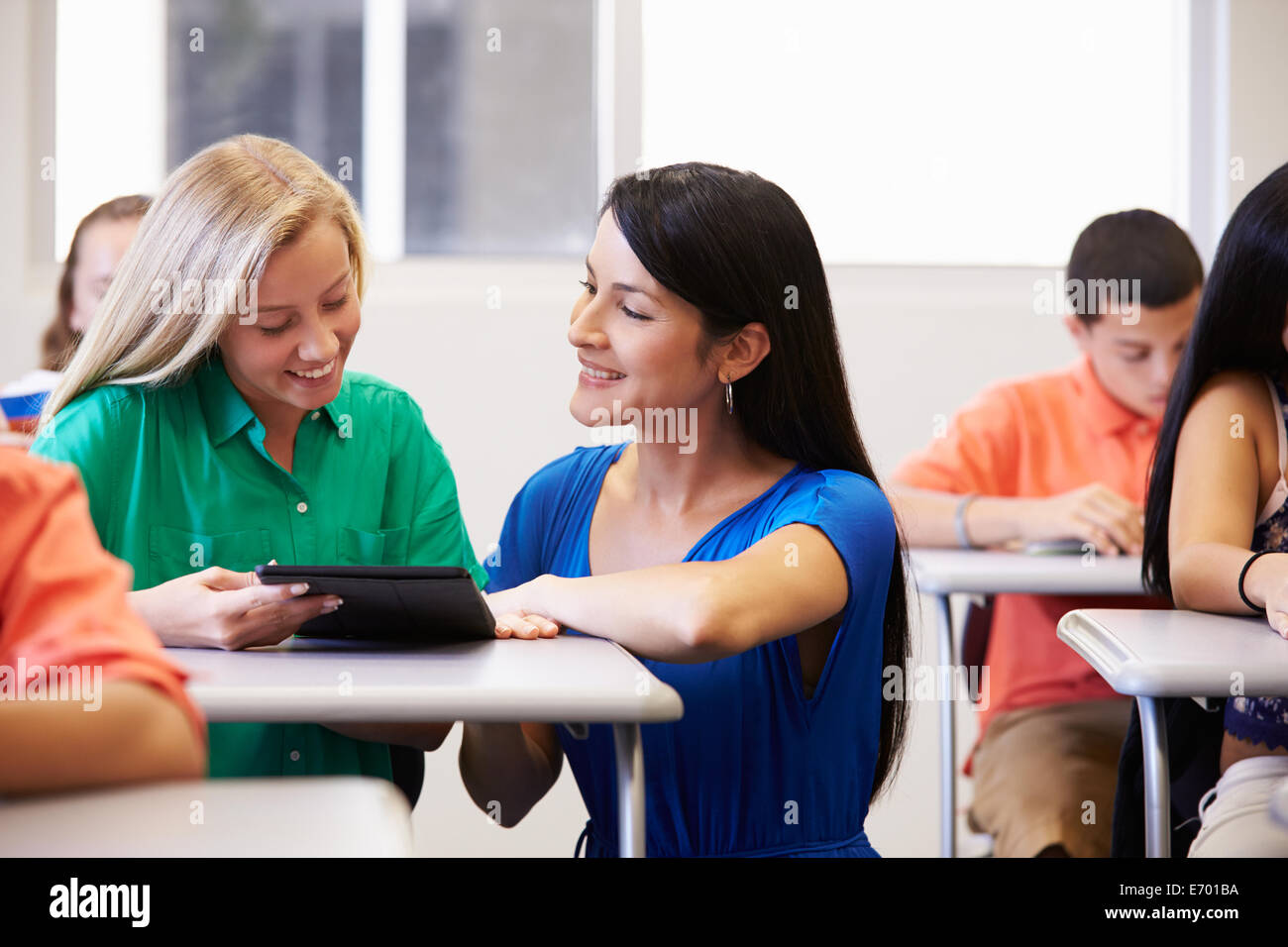 Insegnante femminile aiutando studente di scuola superiore in aula Foto Stock
