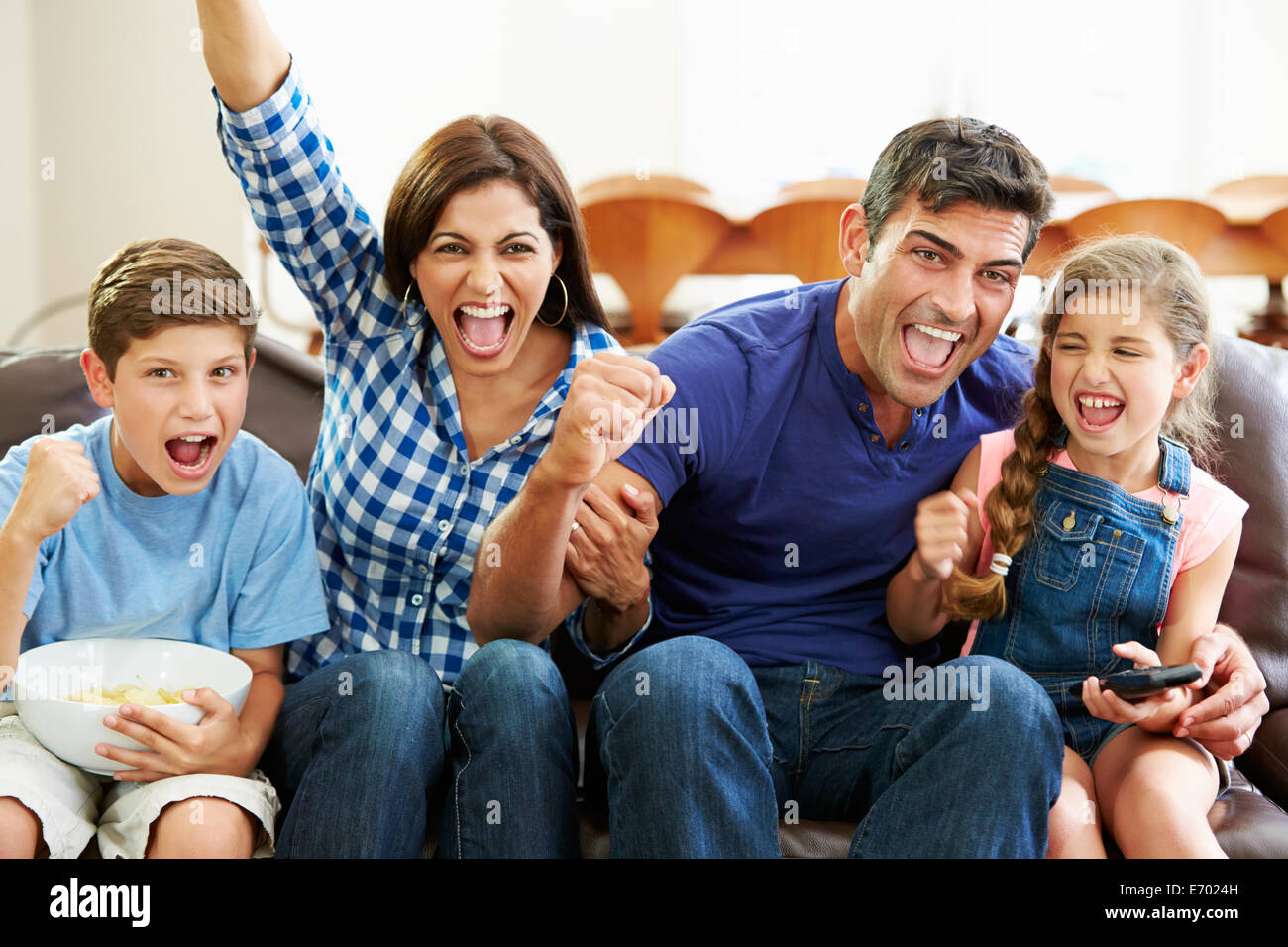 Famiglia guardare partite di calcio celebrando obiettivo Foto Stock