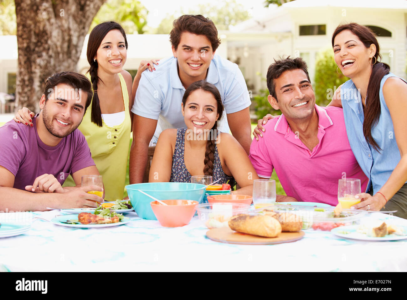 Gruppo di amici celebrando godendo di pasto nel giardino di casa Foto Stock