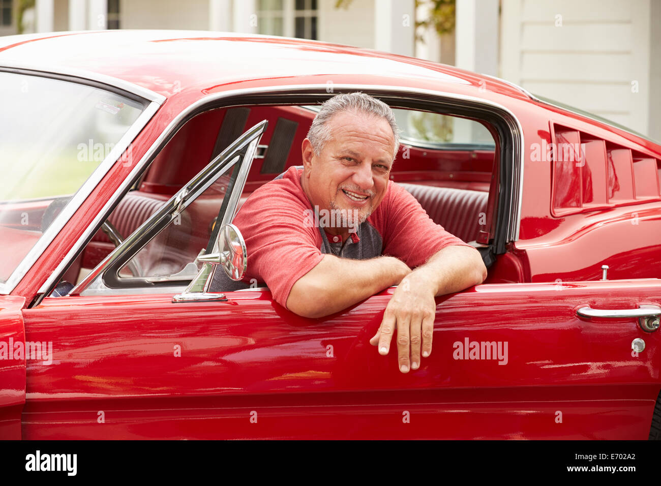 Senior pensionati Uomo seduto in restored Classic Car Foto Stock