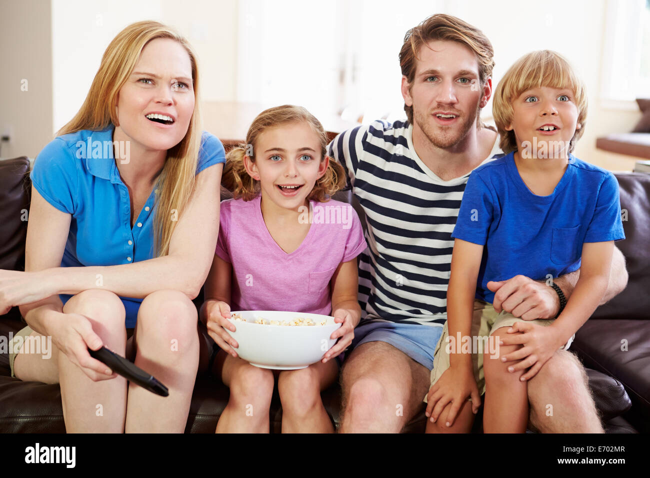 Famiglia seduti sul divano a guardare il calcio insieme Foto Stock