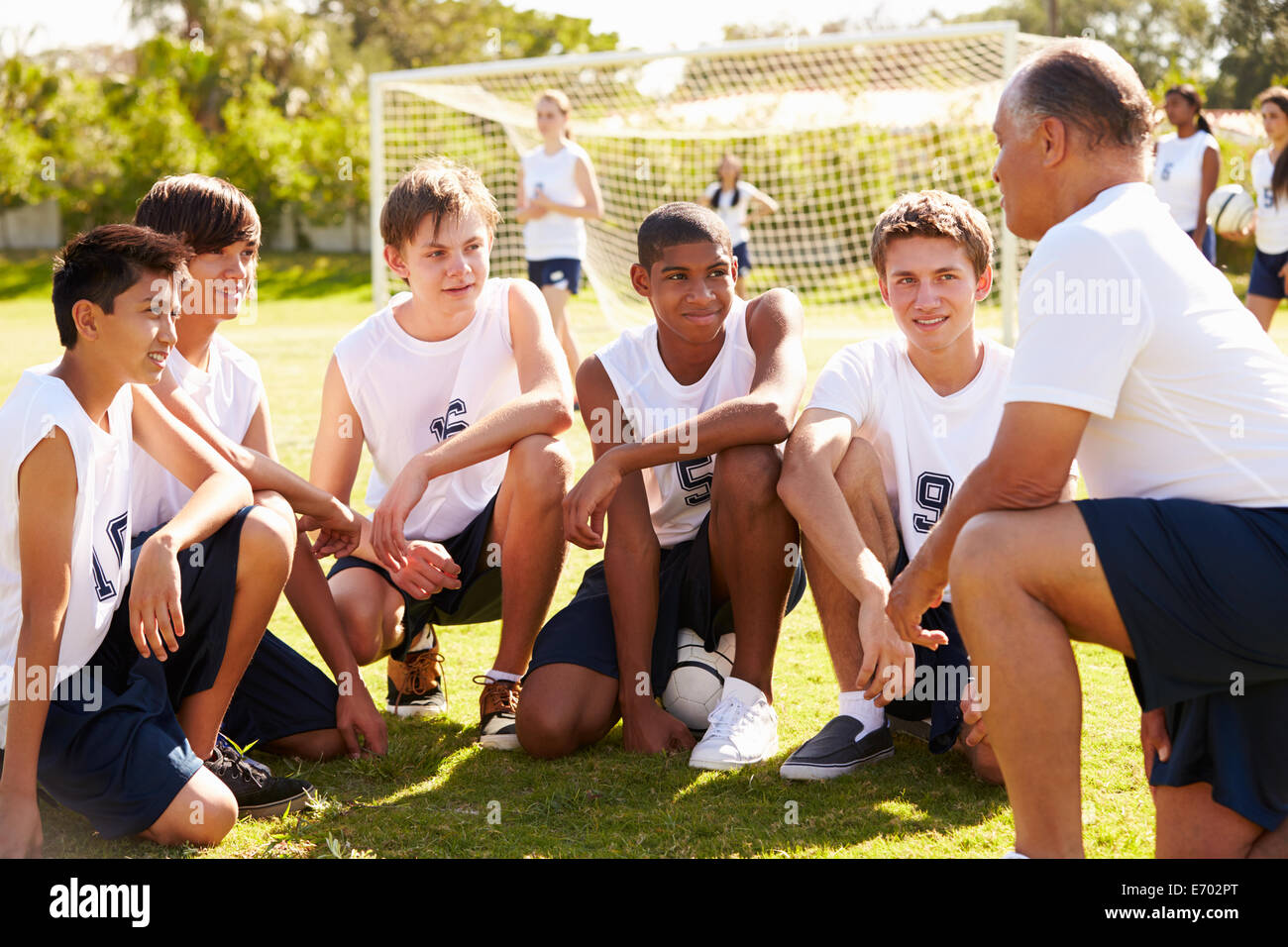 Allenatore dando Team parla con voce maschile di alta scuola calcio Team Foto Stock