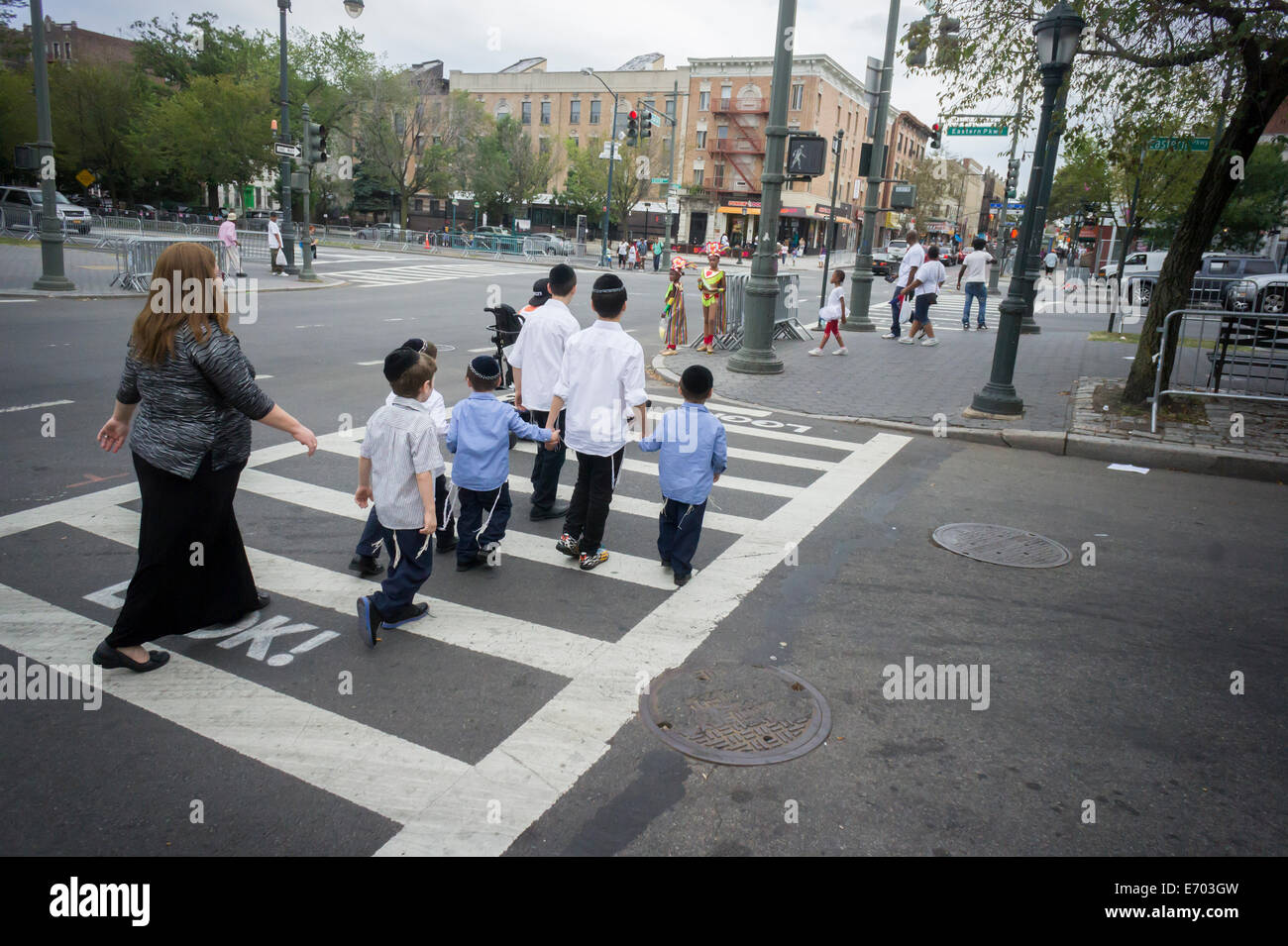 Un ortodosso famiglia ebraica attraversa Eastern Parkway nel quartiere di Crown Heights di Brooklyn a New York Foto Stock