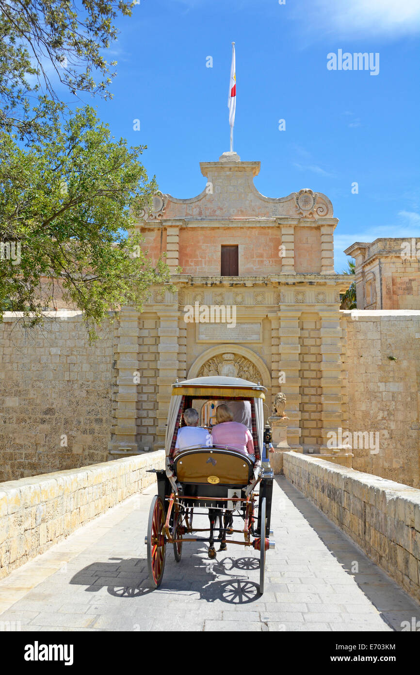 Visite turistiche carro trainato da cavalli con i turisti entrare City gate presso la città silenziosa di Mdina un borgo medioevale Foto Stock