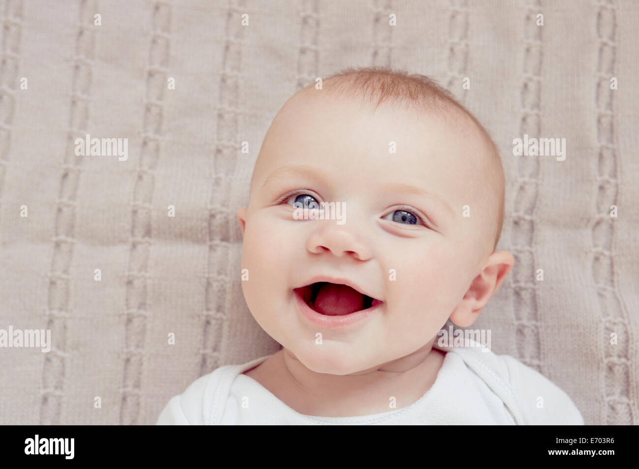 Close up ritratto di sorridere Bimbo giacente su una coperta Foto Stock