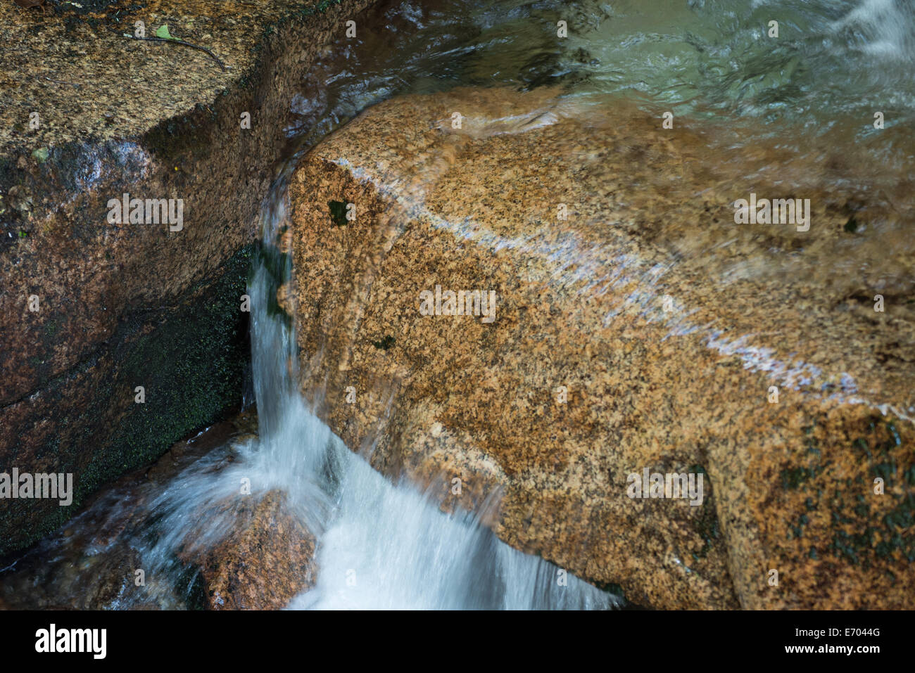 L'acqua precipita attraverso la pietra, la levigatura e la sagomatura del rock, carving un percorso verso il basso Foto Stock