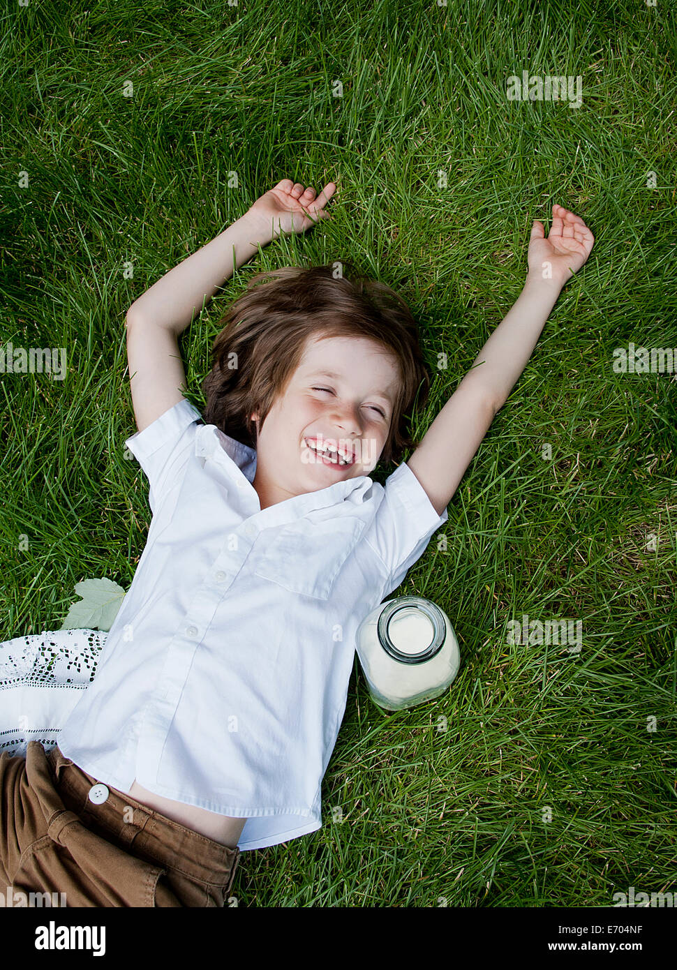 Ragazzo che giace sull'erba ridere Foto Stock